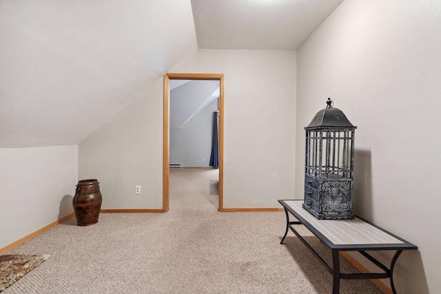 hall featuring lofted ceiling, carpet floors, and baseboard heating