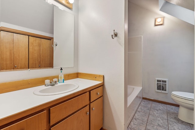 bathroom featuring heating unit, vanity, tile patterned flooring, and toilet