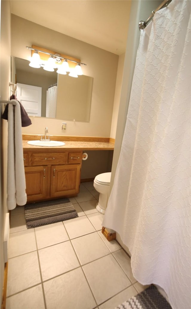 bathroom featuring vanity, tile patterned floors, and toilet