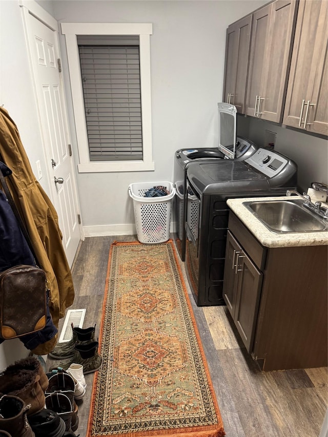 clothes washing area featuring cabinets, separate washer and dryer, sink, and dark wood-type flooring