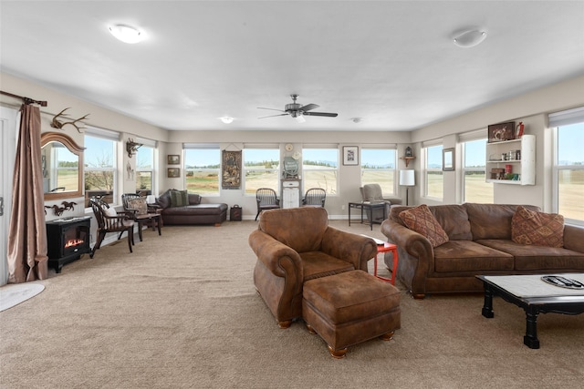 living room with light carpet, ceiling fan, and a wood stove