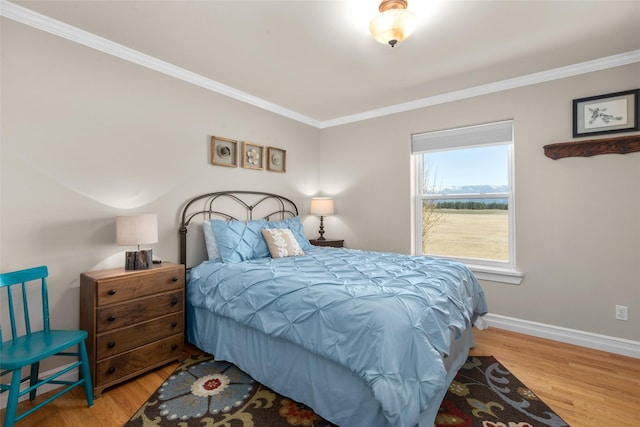 bedroom featuring ornamental molding and light hardwood / wood-style flooring