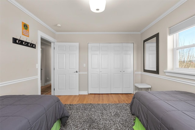 bedroom with crown molding, wood-type flooring, and a closet