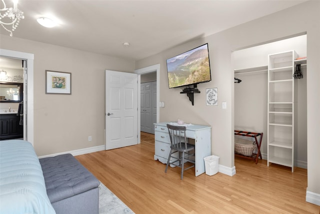 bedroom with a closet, sink, and light hardwood / wood-style flooring