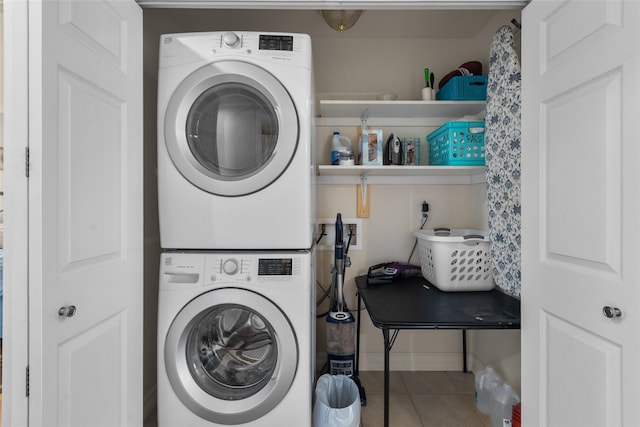 washroom with tile patterned flooring and stacked washer / dryer