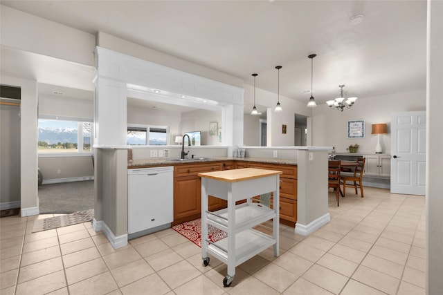 kitchen with pendant lighting, sink, light tile patterned floors, an inviting chandelier, and white dishwasher