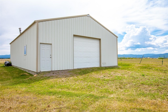 garage featuring a mountain view and a lawn