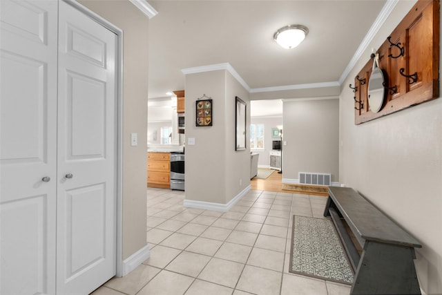 hall featuring ornamental molding and light tile patterned floors