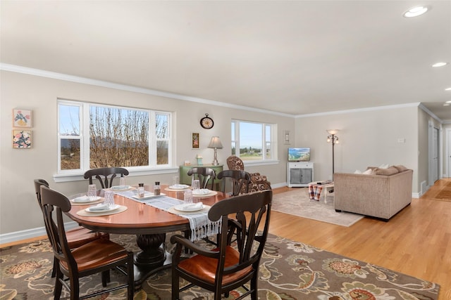 dining room featuring ornamental molding, a healthy amount of sunlight, and light wood-type flooring