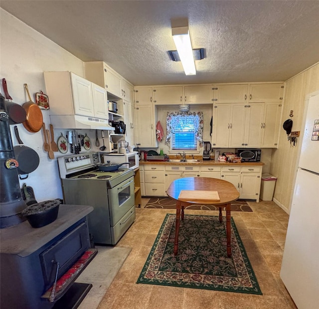 kitchen with sink, range with electric cooktop, a textured ceiling, and white fridge