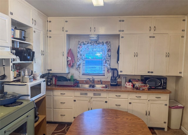 kitchen featuring sink, white cabinets, and white appliances