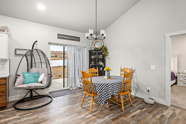 dining space with lofted ceiling, a notable chandelier, and dark hardwood / wood-style floors