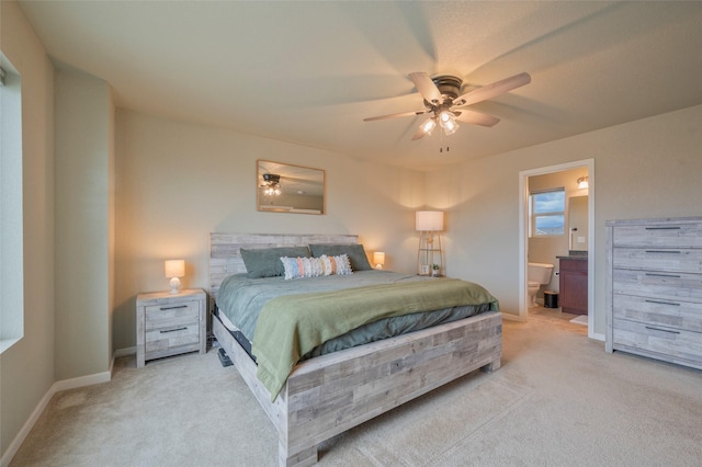 carpeted bedroom with ceiling fan and ensuite bath