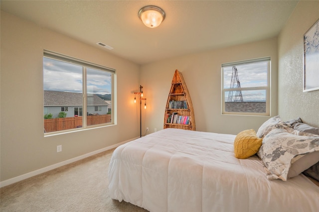 carpeted bedroom featuring multiple windows