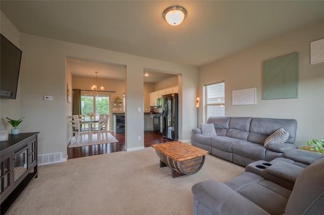 living room with carpet and an inviting chandelier