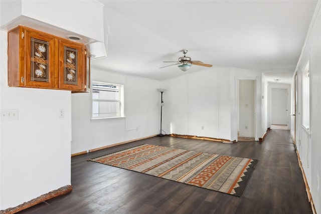 empty room with dark hardwood / wood-style flooring, a wealth of natural light, and ceiling fan