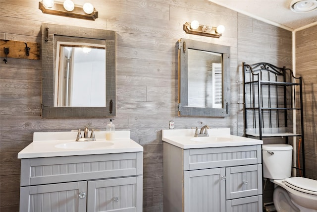 bathroom featuring vanity, wooden walls, and toilet