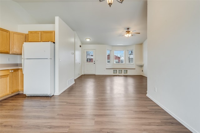 kitchen with white refrigerator, ceiling fan, and light hardwood / wood-style floors