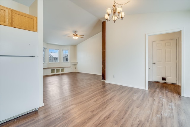 unfurnished living room with lofted ceiling, ceiling fan with notable chandelier, and light hardwood / wood-style floors