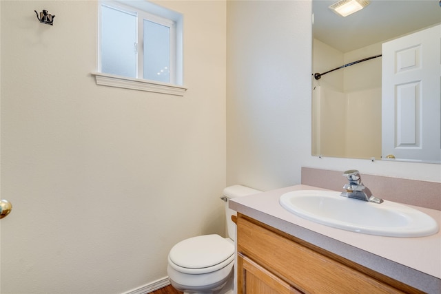 bathroom with vanity, toilet, and walk in shower