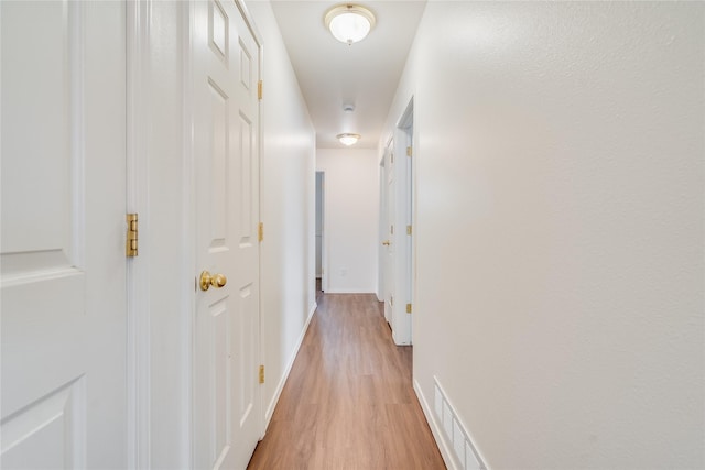 corridor with light hardwood / wood-style flooring