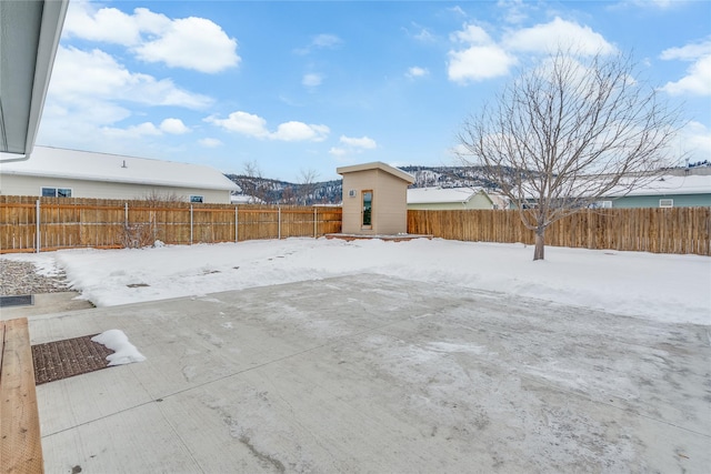 yard layered in snow featuring a storage unit