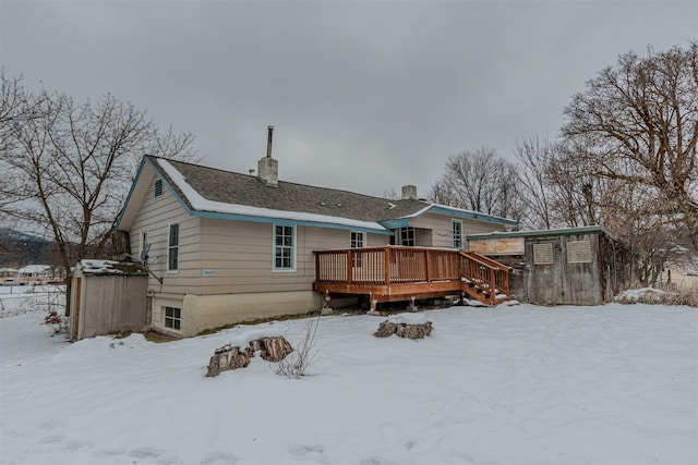 snow covered house featuring a deck