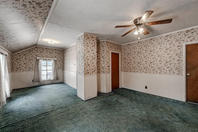 spare room featuring dark colored carpet, ornamental molding, ceiling fan, and a textured ceiling