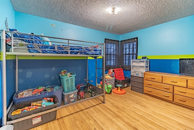 bedroom with hardwood / wood-style floors and a textured ceiling