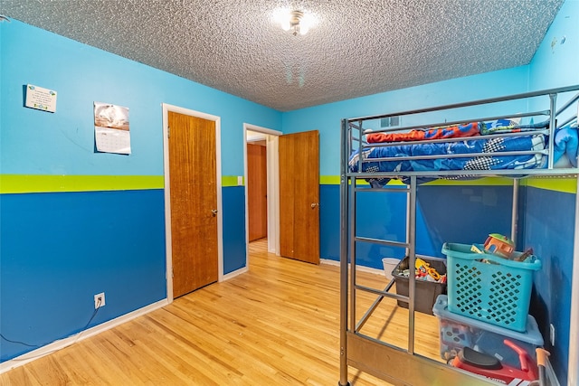 bedroom featuring hardwood / wood-style flooring and a textured ceiling