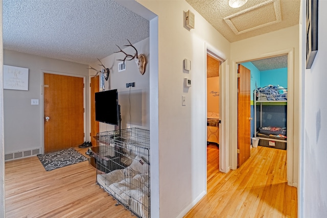 corridor featuring hardwood / wood-style flooring and a textured ceiling