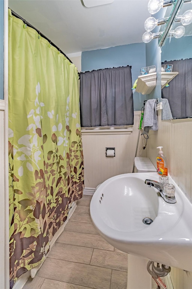 bathroom with wooden walls and sink