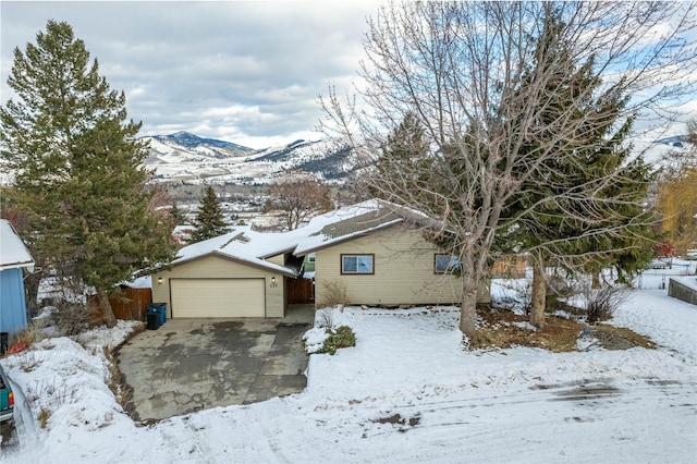 view of front of property with a detached garage, fence, and a mountain view