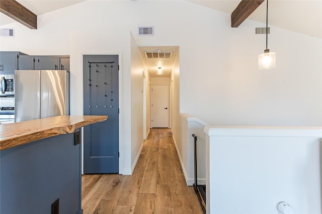 hallway featuring light wood-type flooring, visible vents, and vaulted ceiling with beams