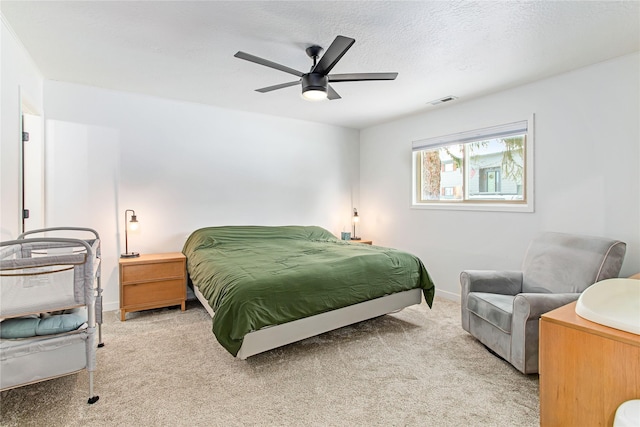 carpeted bedroom with a ceiling fan, baseboards, visible vents, and a textured ceiling