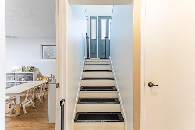 137 Cascade St, Lolo, MT 59847 - stairway featuring wood finished floors and a textured ceiling
