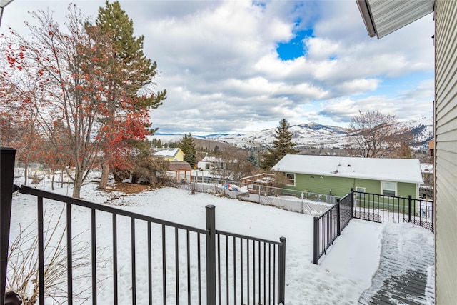 yard layered in snow featuring fence private yard and a mountain view