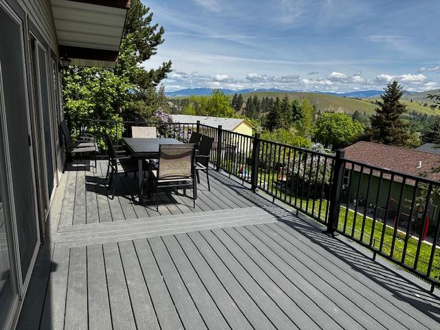 137 Cascade St, Lolo, MT 59847 - wooden deck featuring outdoor dining space and a mountain view