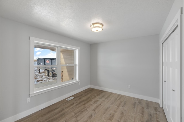 interior space with a textured ceiling and light hardwood / wood-style floors