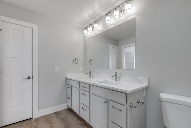 bathroom featuring vanity, hardwood / wood-style floors, a textured ceiling, and toilet