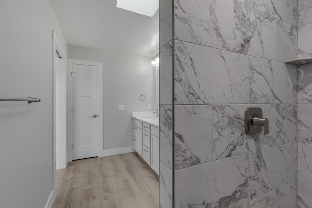 bathroom featuring vanity, a skylight, and wood-type flooring