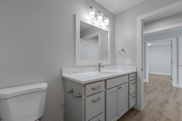 bathroom featuring hardwood / wood-style flooring, vanity, and toilet