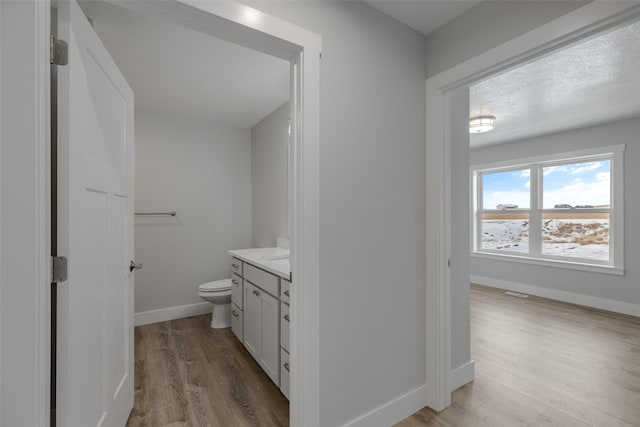 bathroom with vanity, toilet, hardwood / wood-style floors, and a textured ceiling