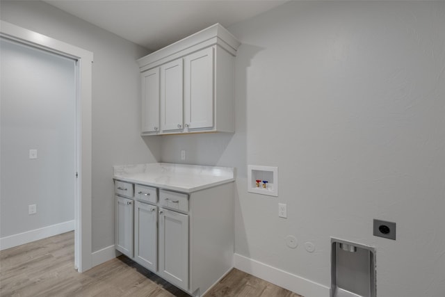 washroom with gas dryer hookup, hookup for a washing machine, cabinets, hookup for an electric dryer, and light wood-type flooring