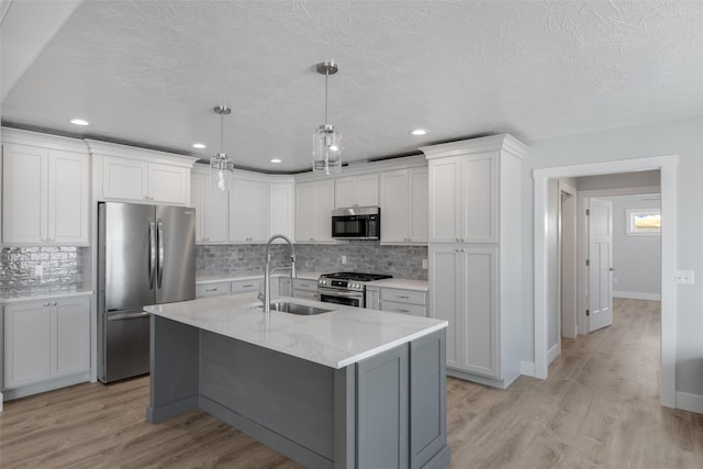 kitchen with white cabinetry, an island with sink, stainless steel appliances, and sink