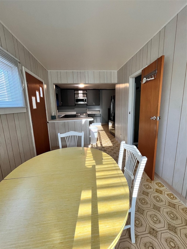 dining space featuring wooden walls