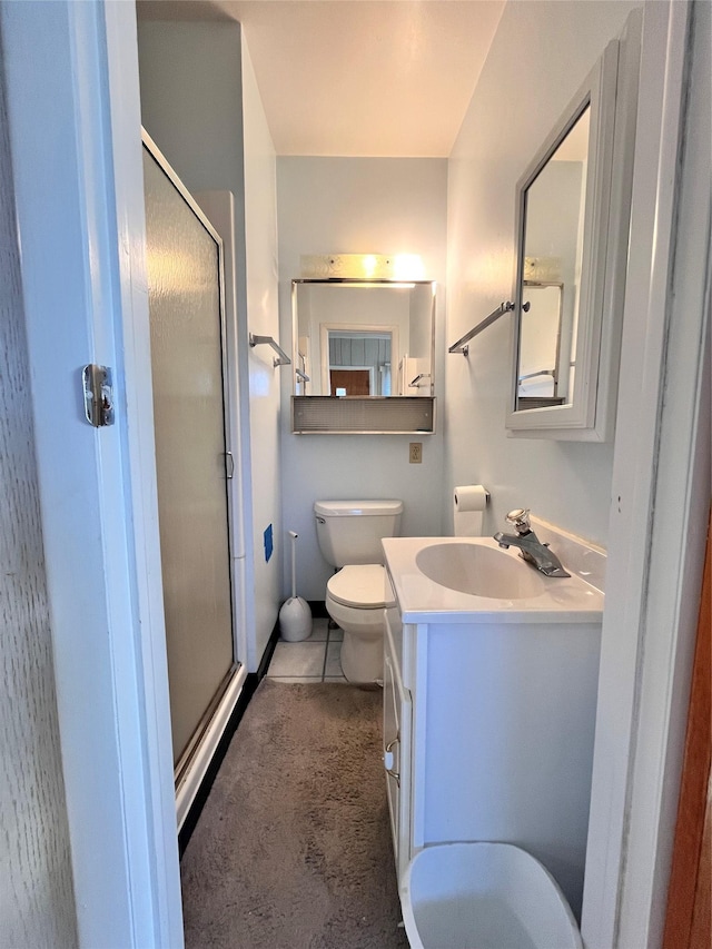 bathroom with tile patterned flooring, vanity, toilet, and a shower with shower door