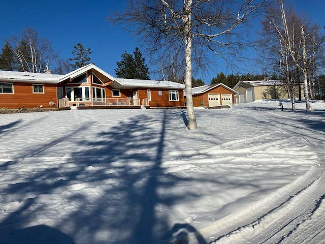 single story home with a porch, an outdoor structure, and a garage