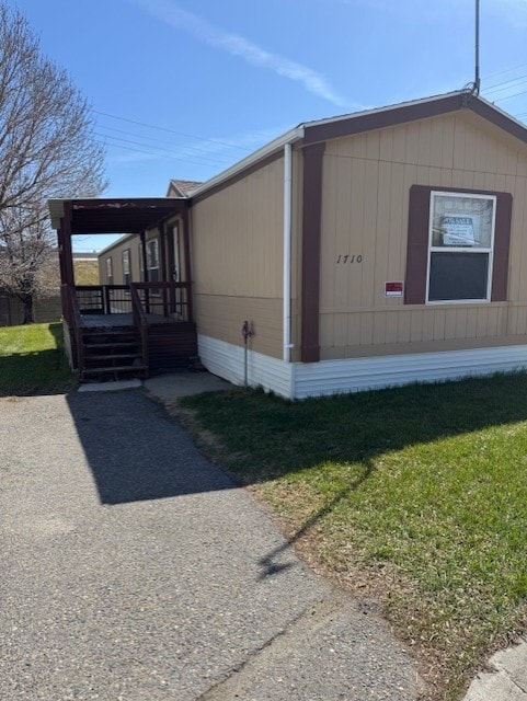 view of side of property featuring a yard and a wooden deck