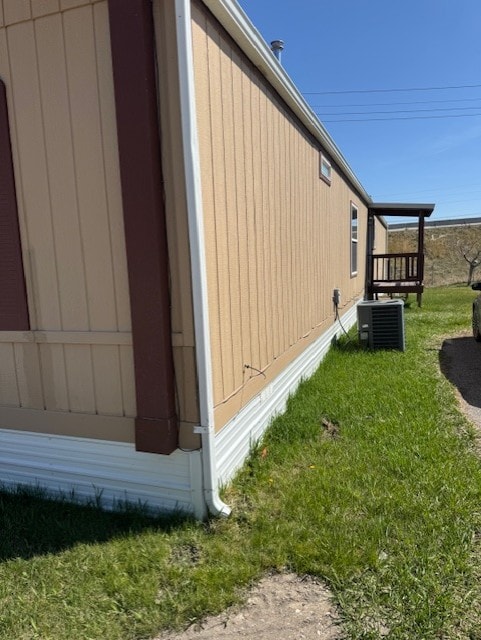 view of side of home with a yard and cooling unit
